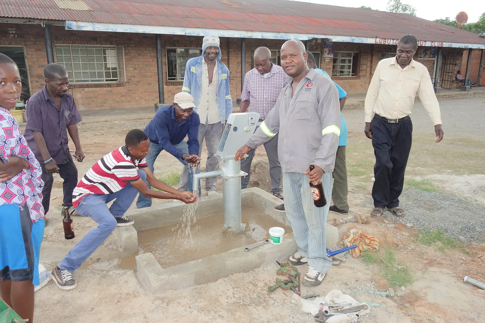 Technician inspecting a wellhead and pressure tank during a home-sale inspection in Hays County